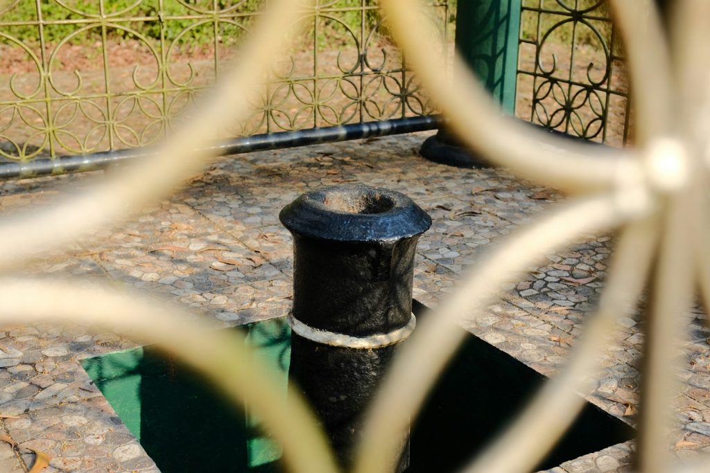 Una boca de incendios negra junto a una valla